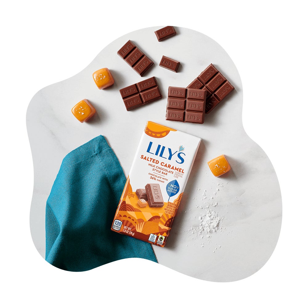 lilys salted caramel milk chocolate style bar beside chocolate pieces and caramel cubes